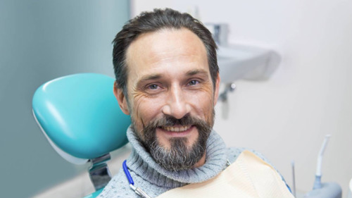 Smiling patient sitting in dental chair during exam at Comfortable Dentistry in Coral Gables, FL